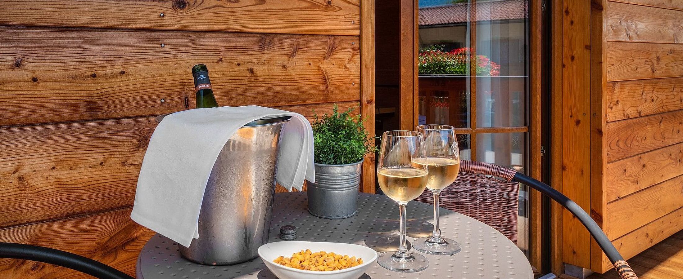 Kühler Wein mit knusprigen Snacks von der Bar auf einem Balkon