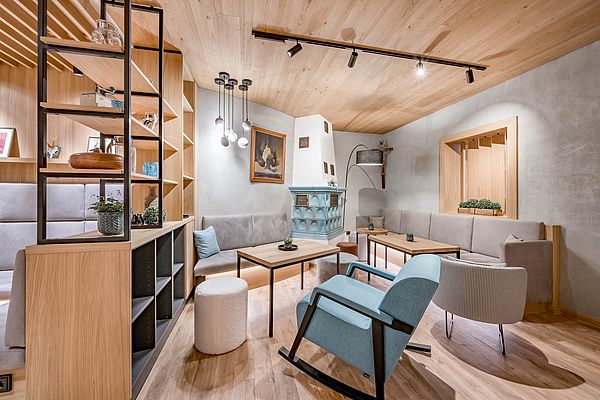 Moderne Lounge mit traditionellem Kachelofen und Schaukelstuhl