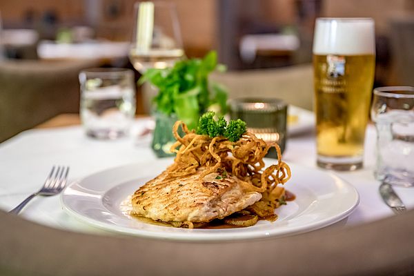 Gebratener Fisch mit Röstzwiebeln und einem Glas Bier