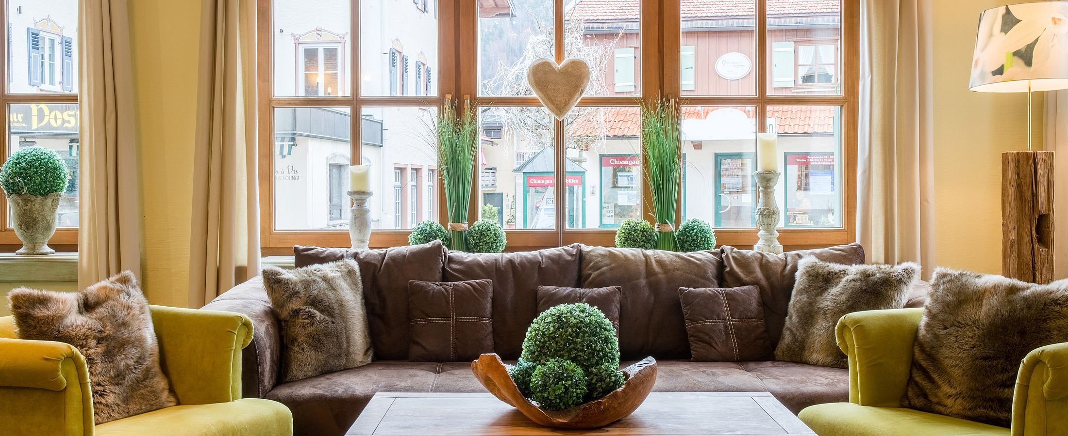 Hotellounge mit gemütlichen Möbeln und Blick auf den Ortskern