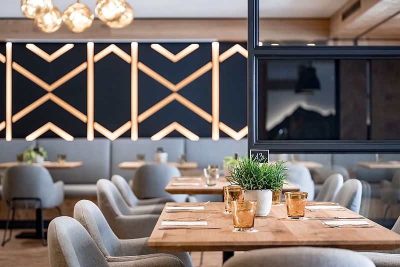 Gedeckter Holztisch mit bequemen Stühlen im Speisesaal