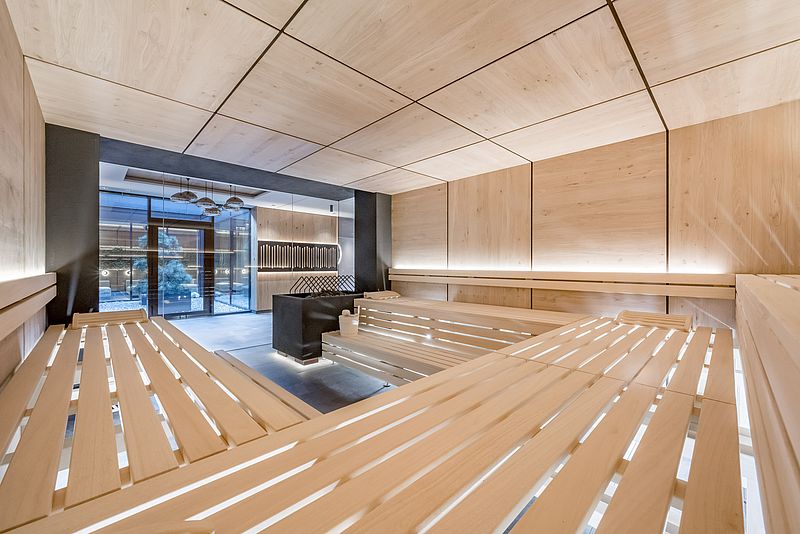 Blick von der modernen Sauna mit großem Saunaofen in den Wellnessbereich